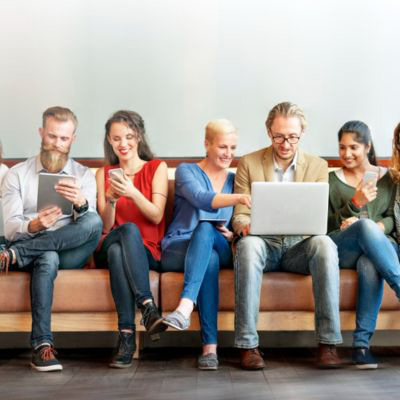 Group of people on their laptops and phones on a couch.