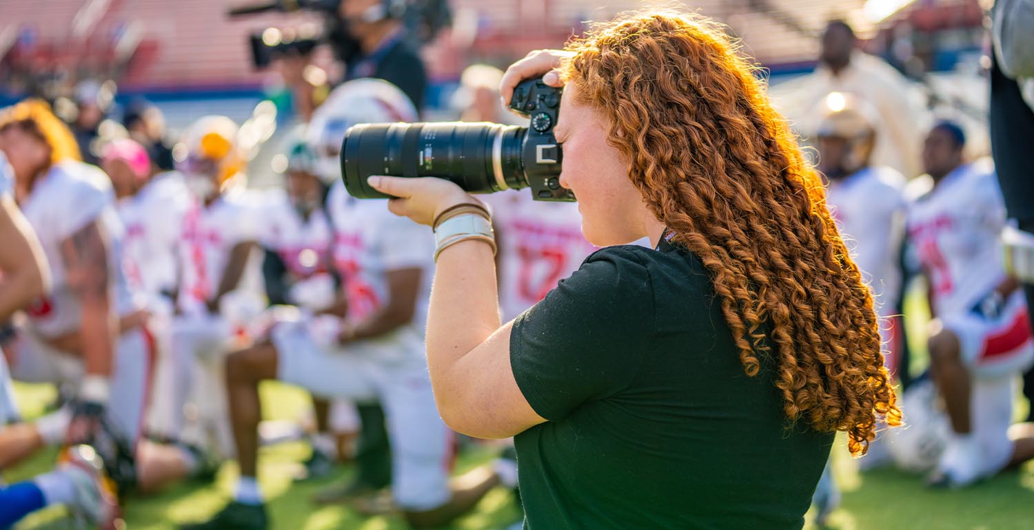 Mason Van Deventer, a freshman majoring in sport management, captures photos at a Senior Bowl practice at Hancock Whitney Stadium on the University of South Alabama campus. 