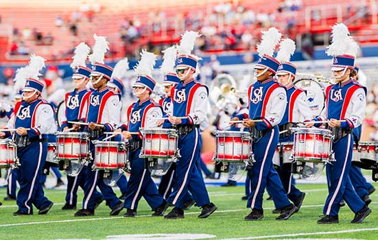 Jaguar Marching Band drumline performing on football field.